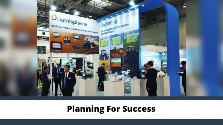 Custom trade show booth design with large-format graphics, digital displays, and attendees engaging at an industry expo