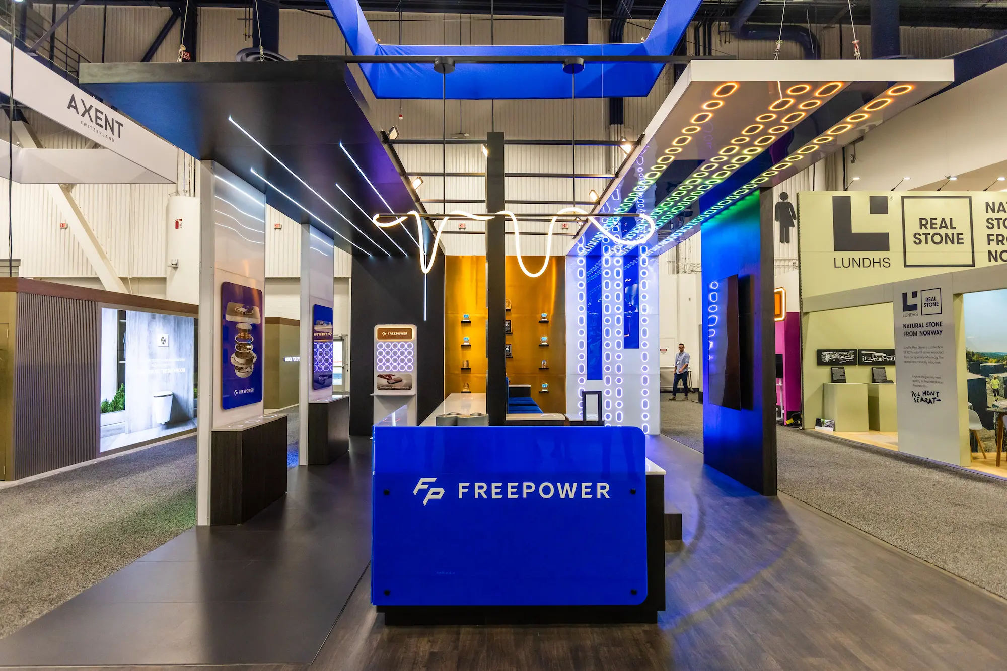 Modern trade show booth design for FreePower at KBIS and IBS 2025 featuring illuminated architecture and interactive product displays.