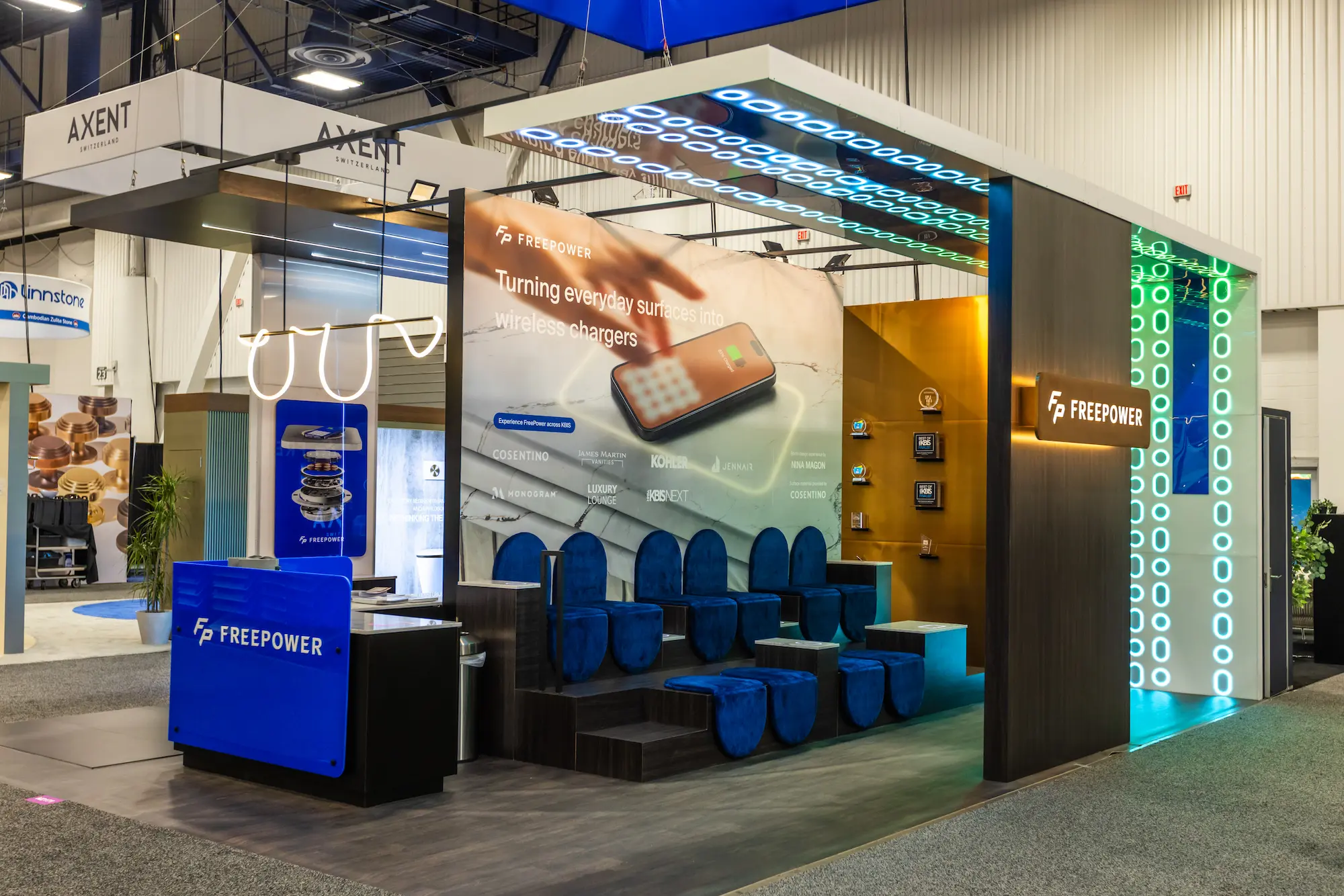 FreePower trade show booth at KBIS and IBS 2025 designed by Highway 85 Creative, featuring illuminated panels, custom seating, and branded digital displays.