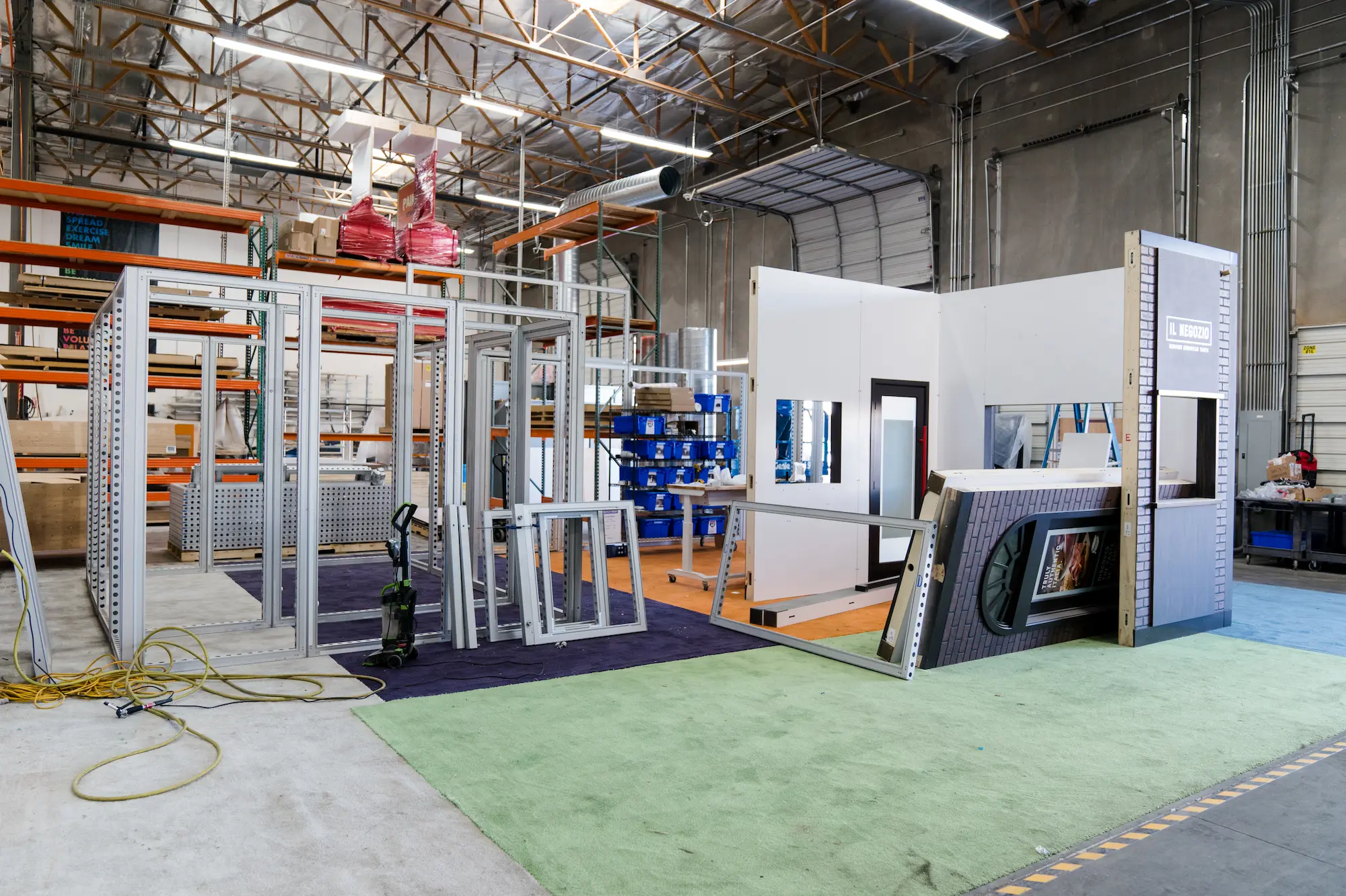 Trade show exhibit pre-build and QC testing in Highway 85's fabrication shop showing aluminum framing, modular wall panels, and booth components being assembled