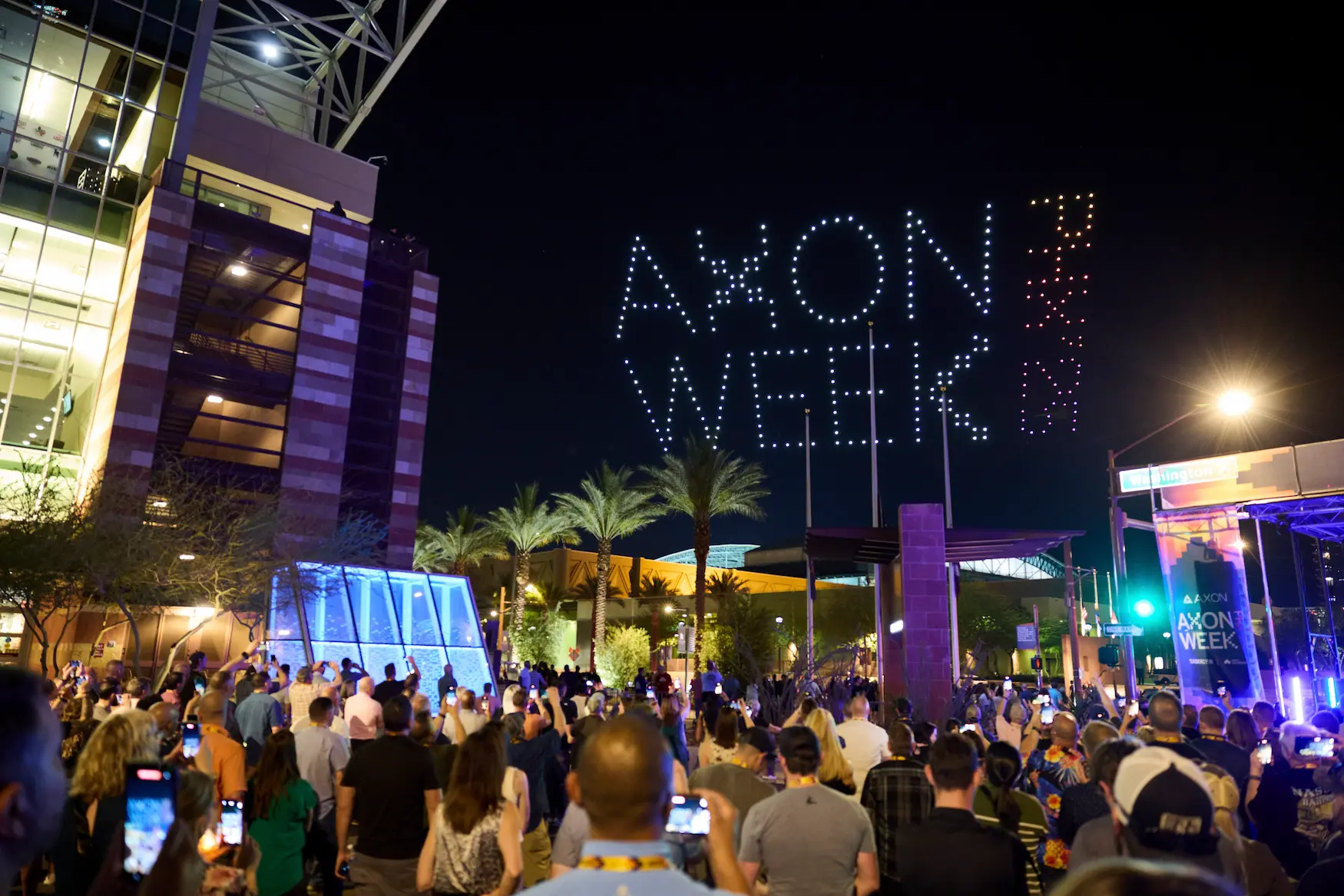 Axon Week 2025 outdoor corporate event with drone light show spelling Axon Week in the night sky above a crowd of attendees produced by Highway 85 Productions
