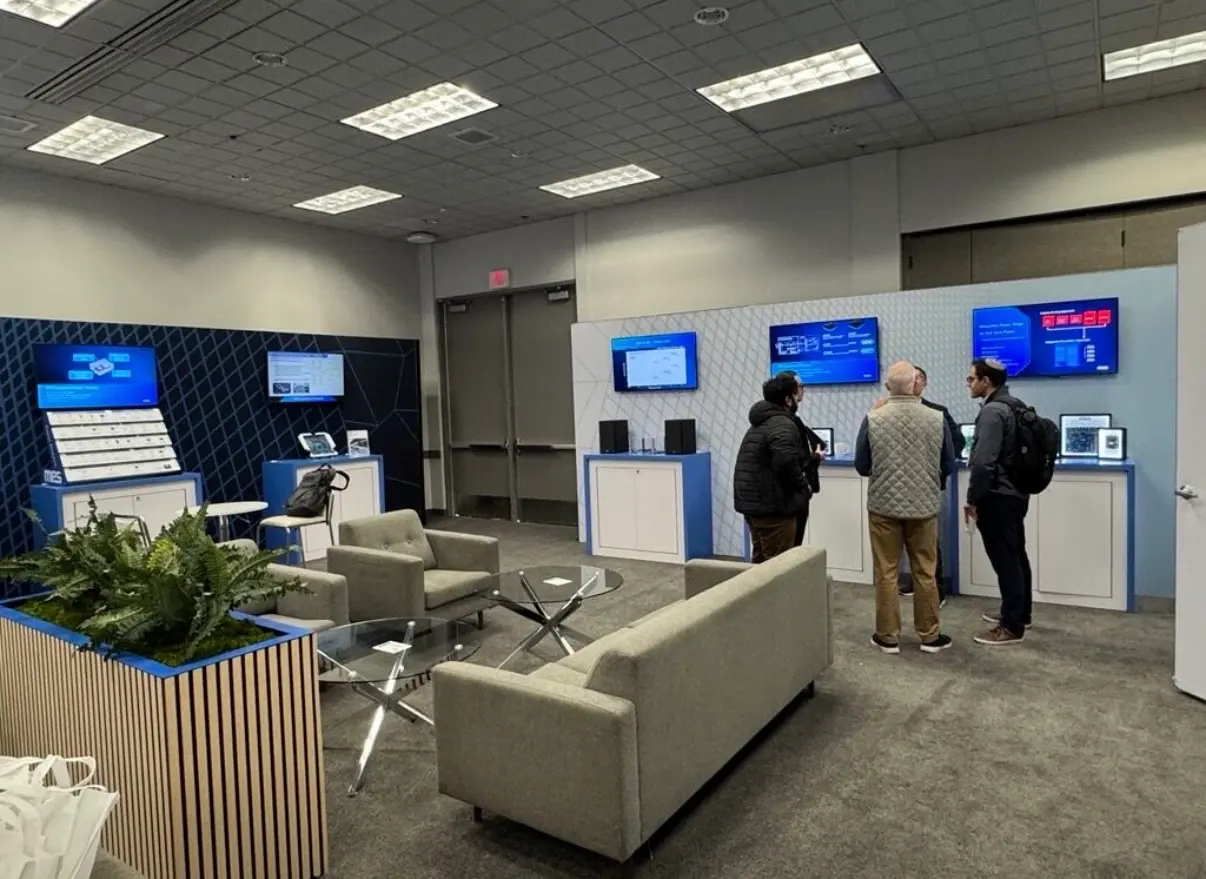 Hybrid corporate event meeting room setup at CES 2026 with branded display screens, lounge seating, and interactive product stations produced by Highway 85 Productions