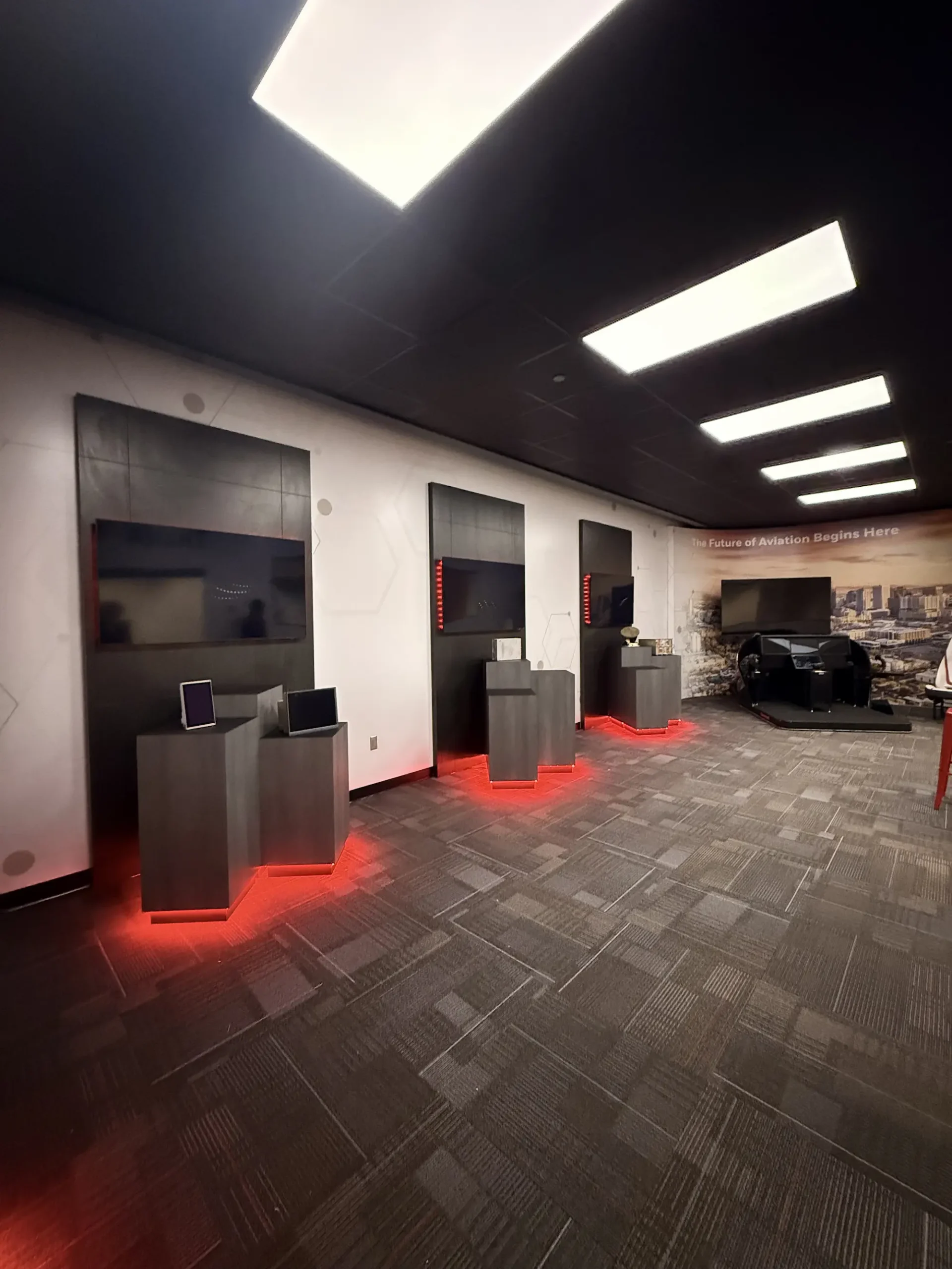 Honeywell aviation showroom permanent interior installation with custom branded display pedestals, LED lighting, and large format wall graphics by Highway 85 Productions