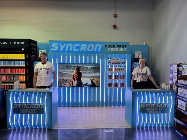 Syncron branded trade show booth with custom fabricated arch display and LED elements produced by Highway 85 Productions for an agency client