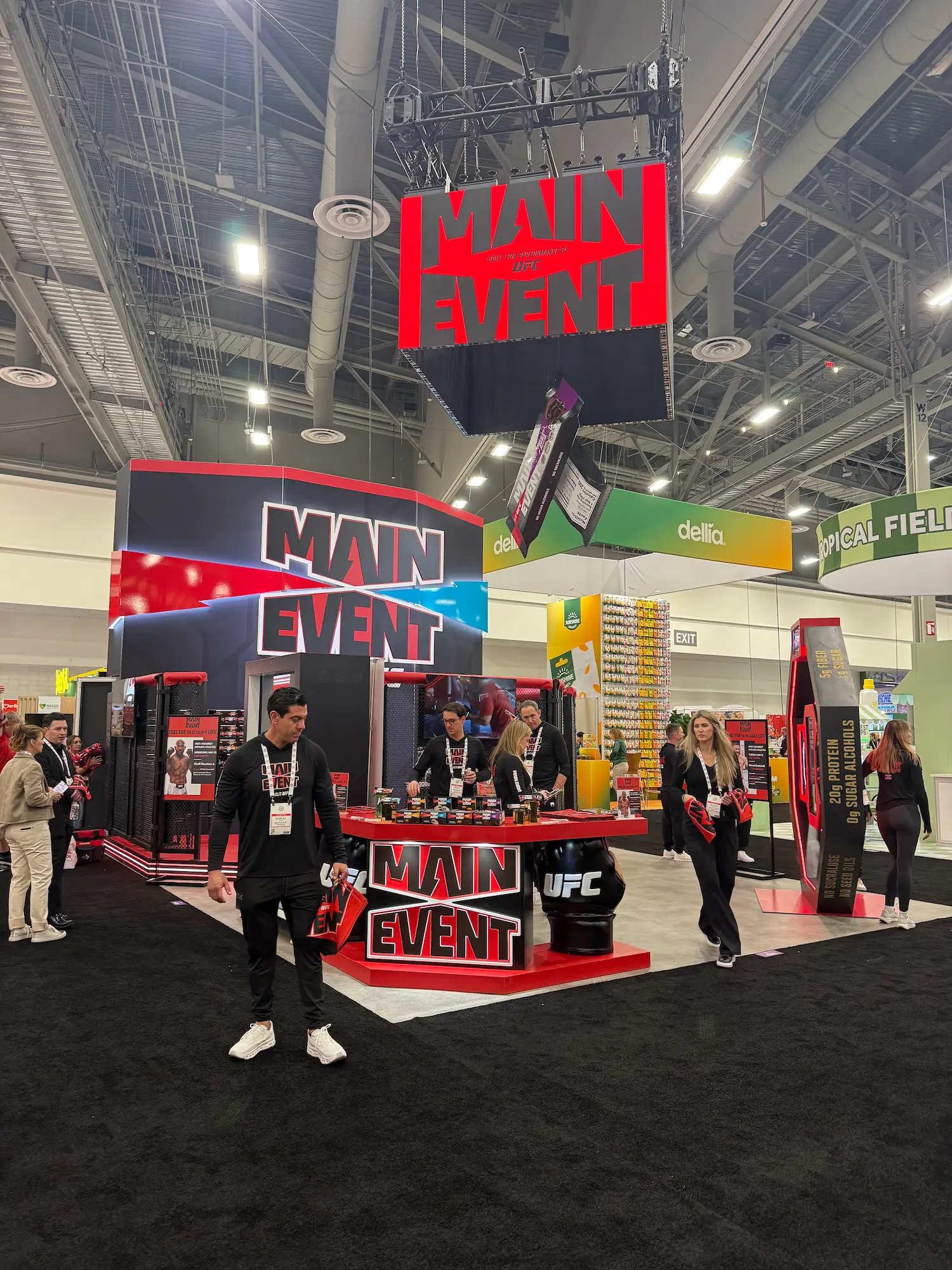 Main Event UFC custom trade show fabrication with dimensional hanging sign, branded counters, and immersive booth environment by Highway 85 Productions
