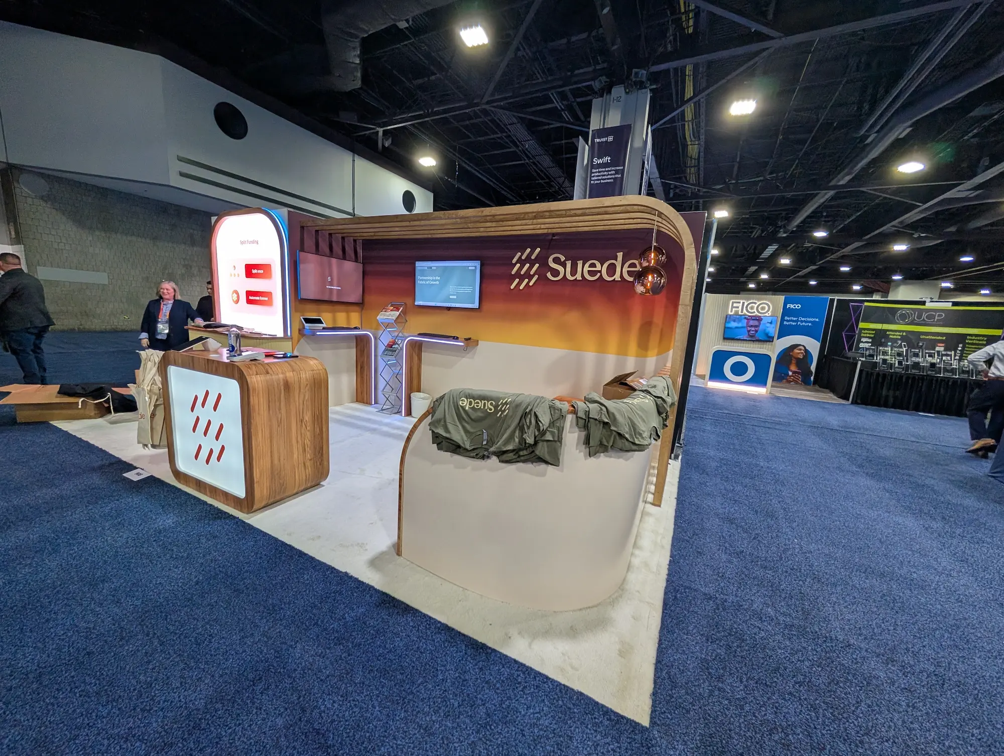 Suede Financial custom trade show booth with wood grain curved structure and branded graphics showing a reusable multi-show trade show booth design by Highway 85 Productions