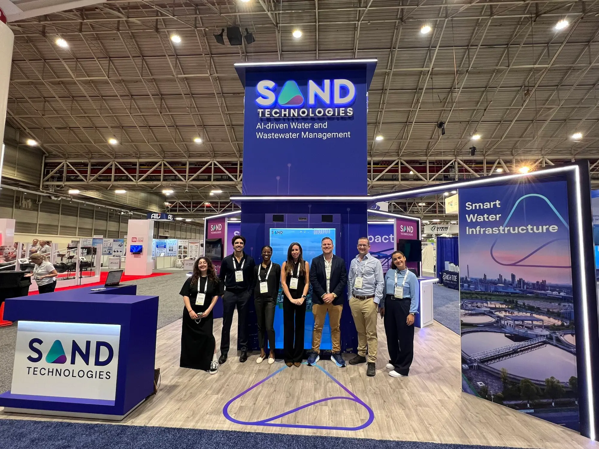 Sand Tech trade show booth sales team working the show floor in a custom exhibit designed for staff movement and lead capture by Highway 85 Productions